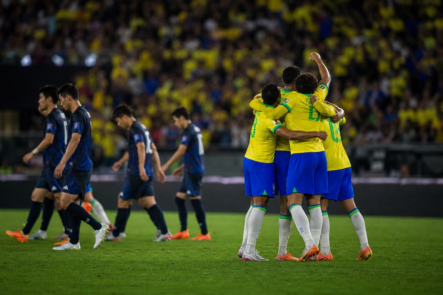 Braziliaanse spelers vieren een late treffer tegen Japan in een gespannen stadionomgeving.
