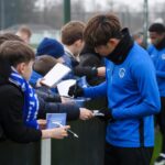 Jonge supporters bij een open training van KRC Genk wachten op handtekeningen