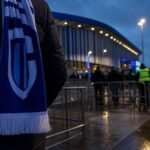 Transfercontext rond KRC Genk met stadionomgeving en gespannen voetbalsfeer zonder herkenbare gezichten