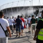 Supporters aan een zonnig WK-stadion met focus op hitte en veiligheidsmaatregelen