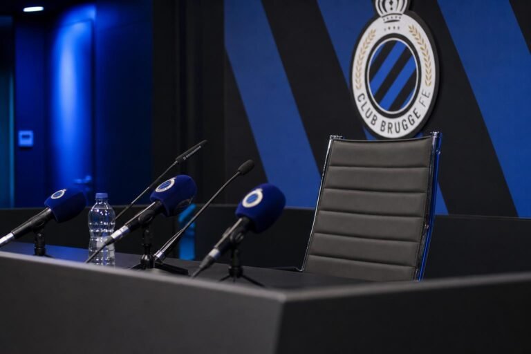 Persomgeving met microfoons en blauw-zwarte accenten rond een afscheid bij Club Brugge