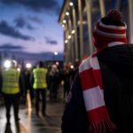 Transferachtige voetbalsfeer rond een stadion bij valavond zonder herkenbare gezichten