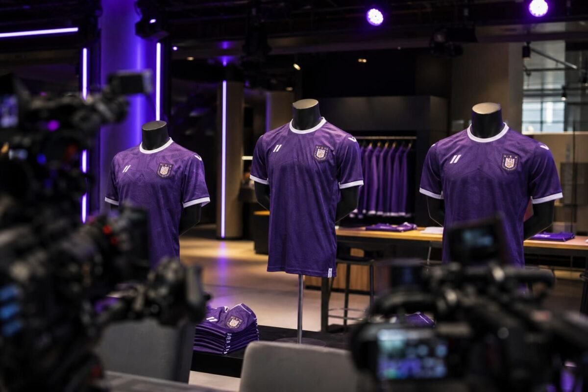 Nieuwe paarse Anderlecht-shirts tijdens een presentatie onder perslichten