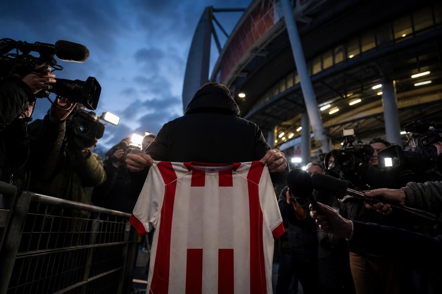 Transfercontext rond PSV en Bayern München met perscamera's en clubkleuren zonder herkenbare gezichten