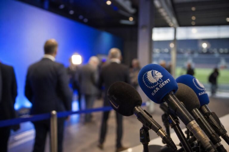 Persmoment in een voetbalstadion rond KAA Gent en de discussie over de competitiehervorming.