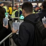 Supporters bij een stadioncontrole met verzegelde drinkflessen voor een WK-wedstrijd