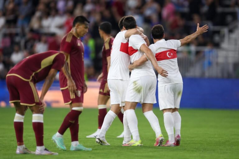 Turkse spelers vieren een doelpunt tijdens een interland in een stadionomgeving