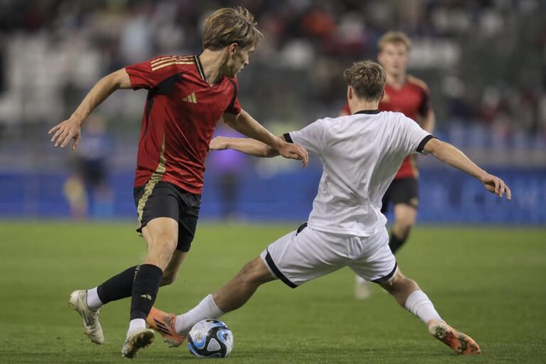 Jeugdvoetballers in een intense wedstrijdsituatie op een internationaal toernooi.