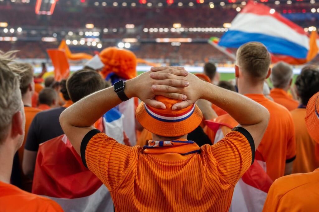 oranje-wk-ambitie-twijfel-aanval-groep Oranje-supporters in een gespannen WK-sfeer rond een stadion