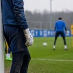 Keeperscontext bij KRC Genk met doelnet en handschoenen tijdens een gespannen trainingsmoment