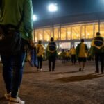 Braziliaanse WK-sfeer met reistassen en voetbalspullen bij een stadioningang.