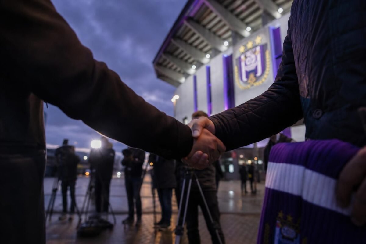 Transfercontext rond RSC Anderlecht met paarse clubkleuren en perscamera’s zonder herkenbare gezichten