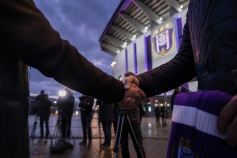 Transfercontext rond RSC Anderlecht met paarse clubkleuren en perscamera’s zonder herkenbare gezichten
