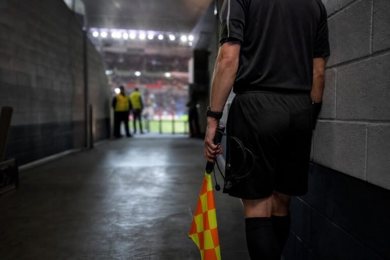 Tense stadium corridor scene with referee atmosphere and no identifiable people