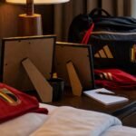 Ingelijste familiefoto’s en Belgische voetbaldetails in de sfeer van een WK-teamhotel.