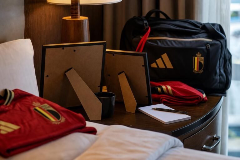Ingelijste familiefoto’s en Belgische voetbaldetails in de sfeer van een WK-teamhotel.