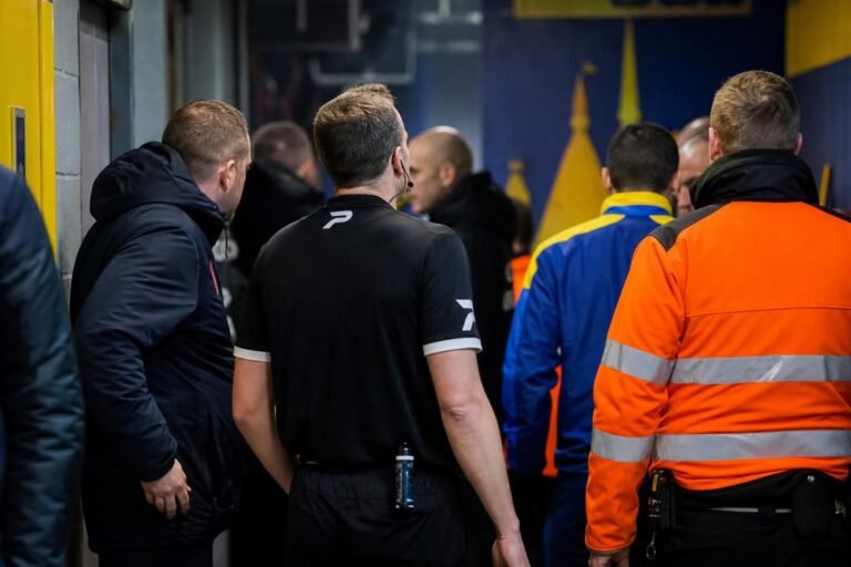 Tense stadium corridor atmosphere after a Westerlo match, linked to a disciplinary incident with referees.