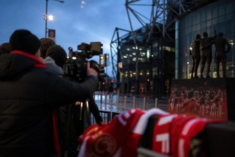 Transfercontext rond Manchester United met stadionomgeving en persdrukte zonder herkenbare personen