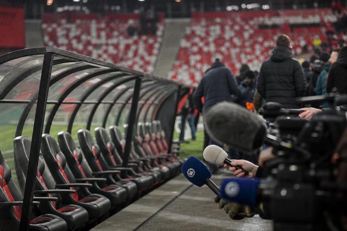 Lege trainersbank en persmicrofoons in een gespannen Feyenoord-context