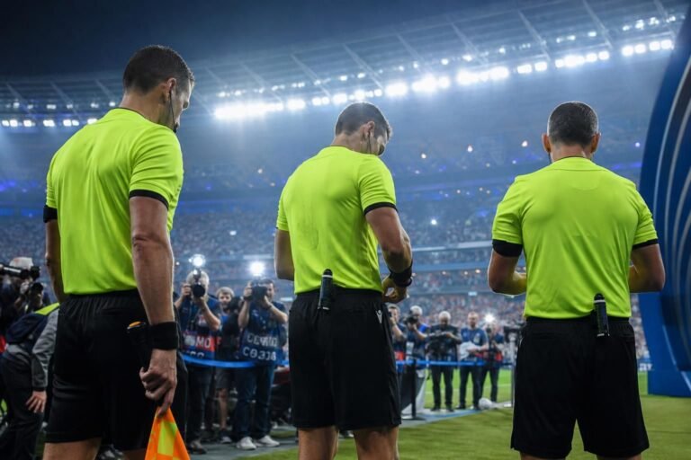 Scheidsrechtersteam in een stadioncontext rond een Europese finale