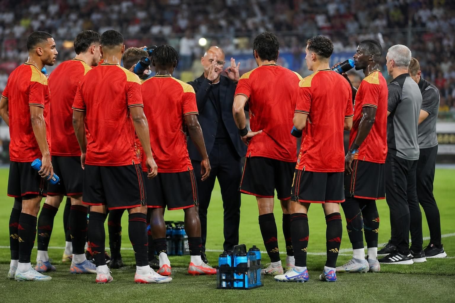 Spelers nemen een drinkpauze tijdens een WK-wedstrijd in een vol stadion