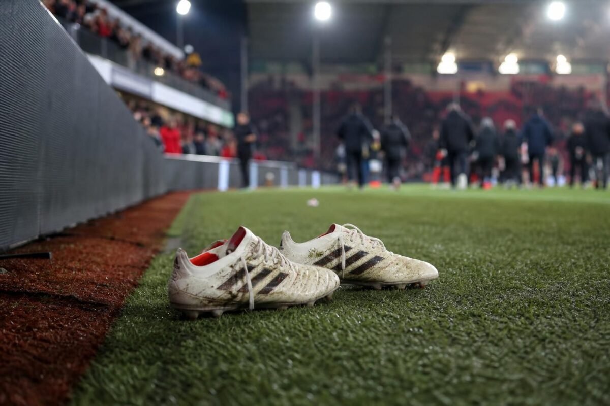 Voetbalschoenen aan de zijlijn als symbool voor het afscheid van Jens Naessens
