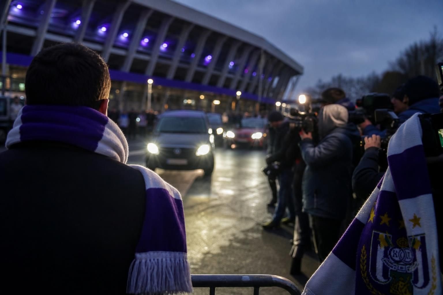 Transfercontext rond RSC Anderlecht met paarse clubkleuren en perscamera's.