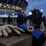Transfercontext rond Club Brugge met doelmanhandschoenen en stadiondrukte zonder herkenbare gezichten