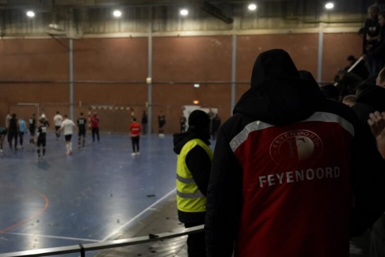 Gespannen sfeer in een zaalvoetbalhal na een incident tijdens een supporterstoernooi