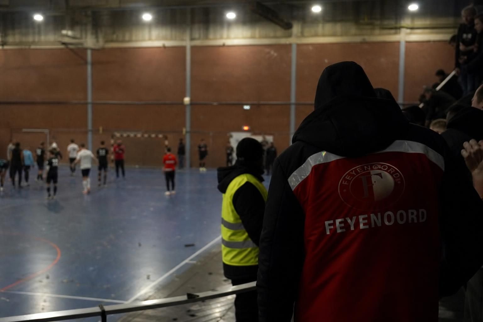 Gespannen sfeer in een zaalvoetbalhal na een incident tijdens een supporterstoernooi