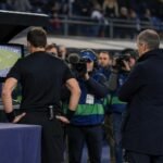 VAR-monitoren in een stadioncontext tijdens een gevoelige arbitragediscussie zonder herkenbare gezichten