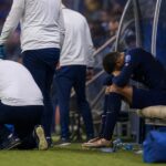 Een aangeslagen speler in Franse wedstrijdcontext zit na een blessuremoment aan de zijlijn, zonder herkenbare gezichten.