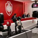 Persmoment rond Royal Antwerp FC met microfoons en rood-witte clubsfeer.