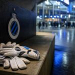Keepershandschoenen in een stadionomgeving van Club Brugge als symbool voor de zoektocht naar een nieuwe doelman.