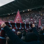 Supporters van West Ham United in een geladen stadionsfeer na de degradatie
