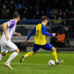 Een Cambuur-verdediger in een intens defensief duel onder stadionlichten.