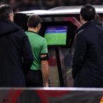 Scheidsrechter bekijkt een videofase langs het veld tijdens een wedstrijd in de Challenger Pro League