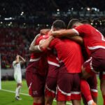 Zwitserse spelers vieren een WK-doelpunt terwijl Algerije teleurgesteld achterblijft
