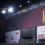 Lege persstoel met microfoons in een voetbalperszaal rond de Rode Duivels.