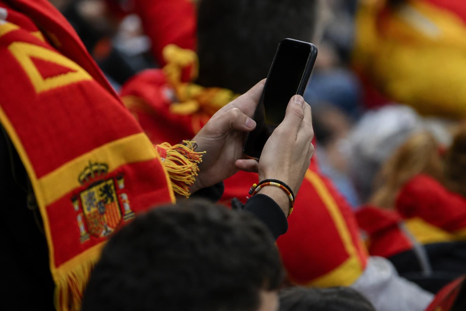 Spaanse voetbalsfeer met supporters en smartphone als symbool voor online reacties rond Inés García en Lamine Yamal