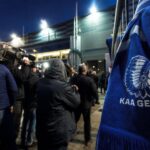 Transfercontext rond KAA Gent met stadionlicht en perssfeer zonder herkenbare gezichten