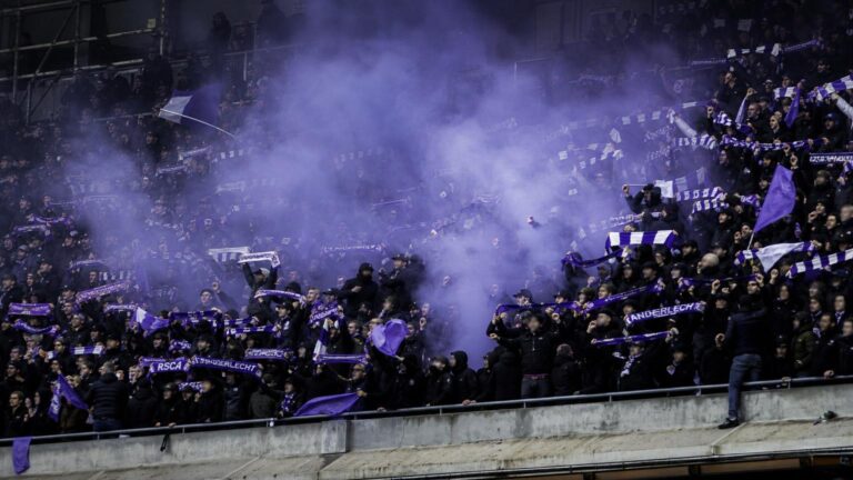 Sfeervol bezoekersvak van RSC Anderlecht-supporters tijdens een geladen derby zonder herkenbare gezichten