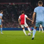 Ajax-middenvelder in duel tijdens een oefenwedstrijd in de Johan Cruijff Arena