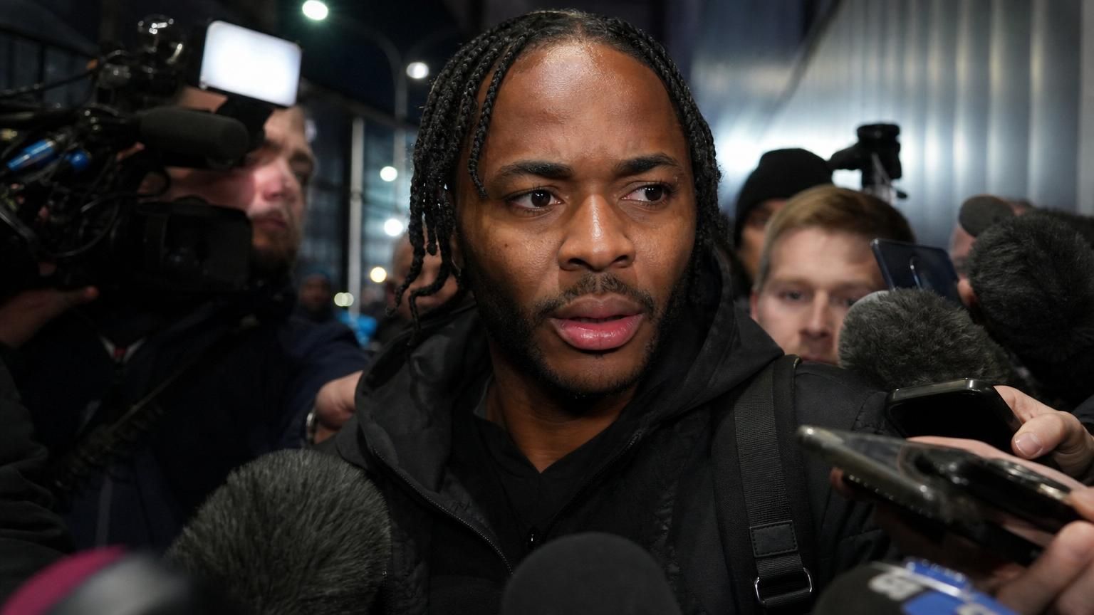 Raheem Sterling in een gespannen perscontext rond een voetbalstadion