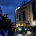 Transfercontext rond Chelsea met blauwe sjaals en cameraflitsen bij het stadion