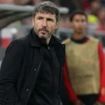 Mark van Bommel geconcentreerd aan de zijlijn in donkere coachkledij