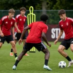 Jeugdspelers en staf van Standard tijdens een training op het oefenveld.