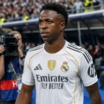 Vinicius Junior wandelt in het tenue van Real Madrid langs de zijlijn.