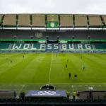 Breed zicht op het Wolfsburg-stadion in gebruik met kleine groepen rond het veld