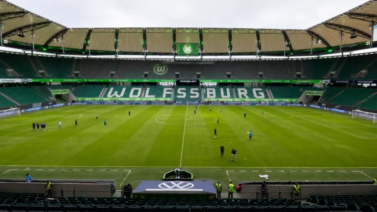 Breed zicht op het Wolfsburg-stadion in gebruik met kleine groepen rond het veld